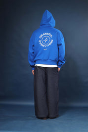 Model wearing Honest to God Cobalt Blue boxy hoodie for a 90s inspired international vibe.