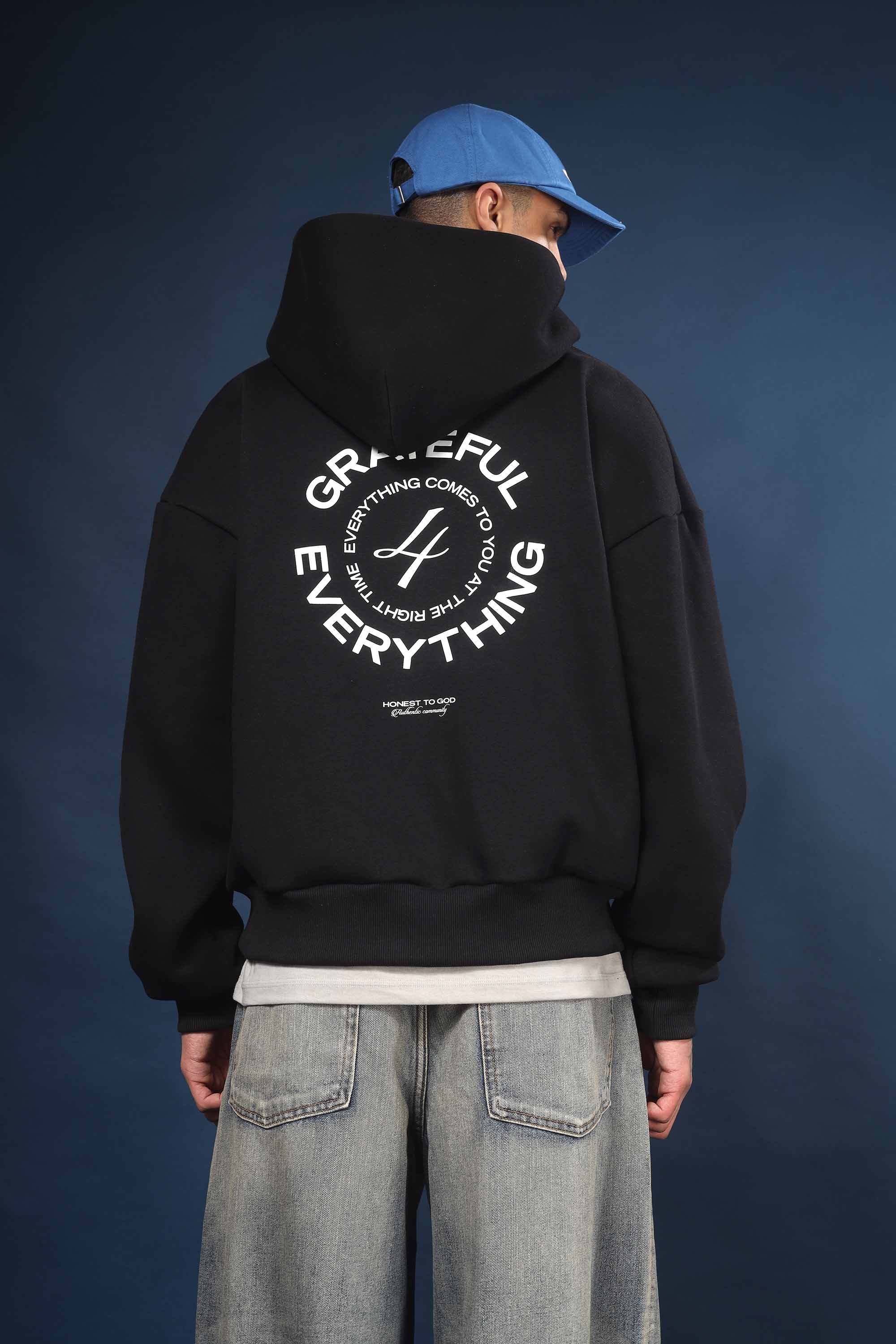 Model wearing Honest to God Black boxy hoodie for a 90s inspired international vibe.