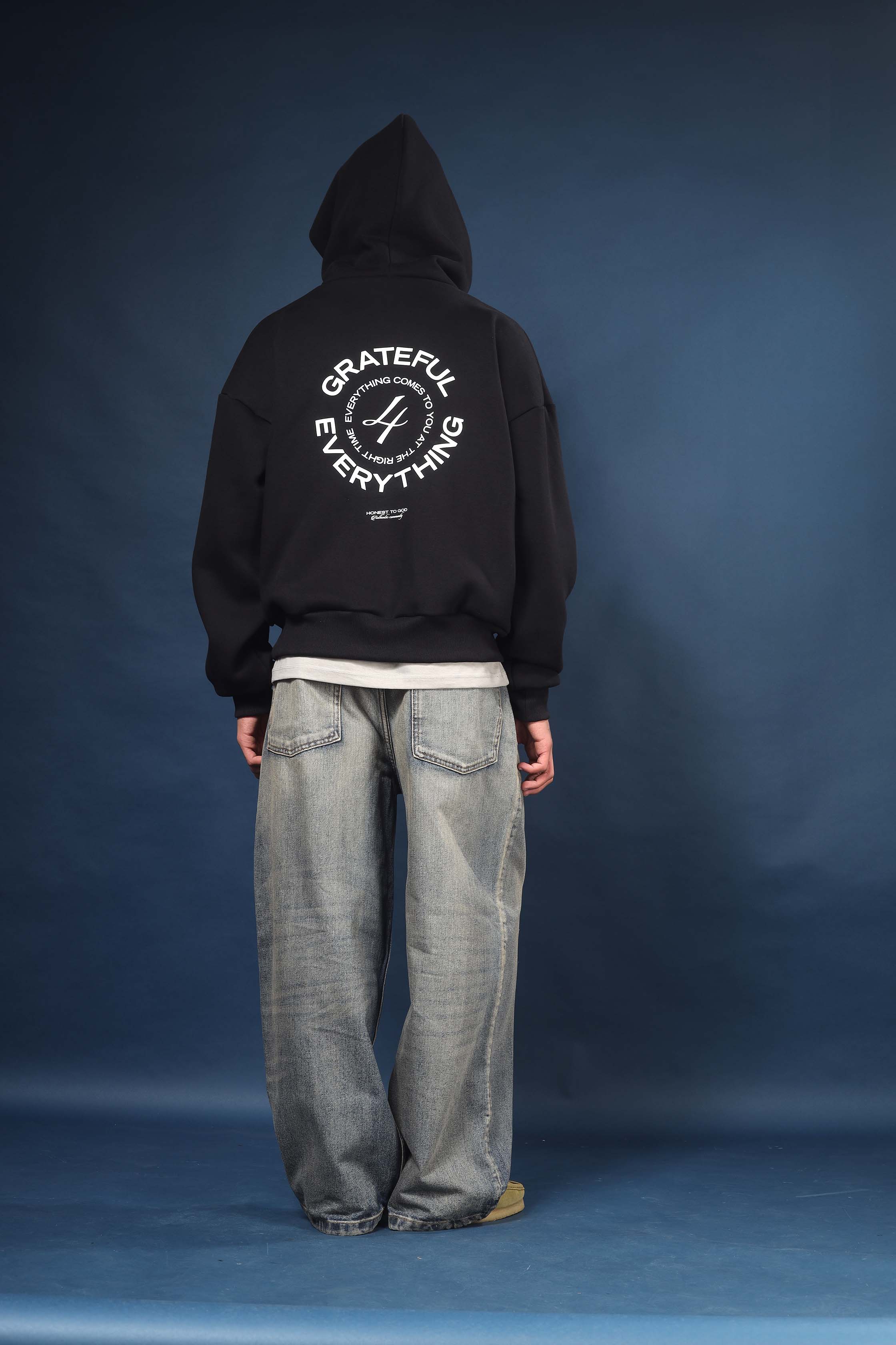 Model wearing Honest to God Black boxy hoodie for a 90s inspired international vibe.