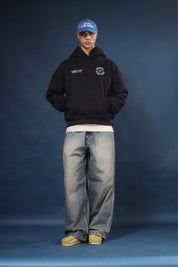 Model wearing Honest to God Black boxy hoodie for a 90s inspired international vibe.