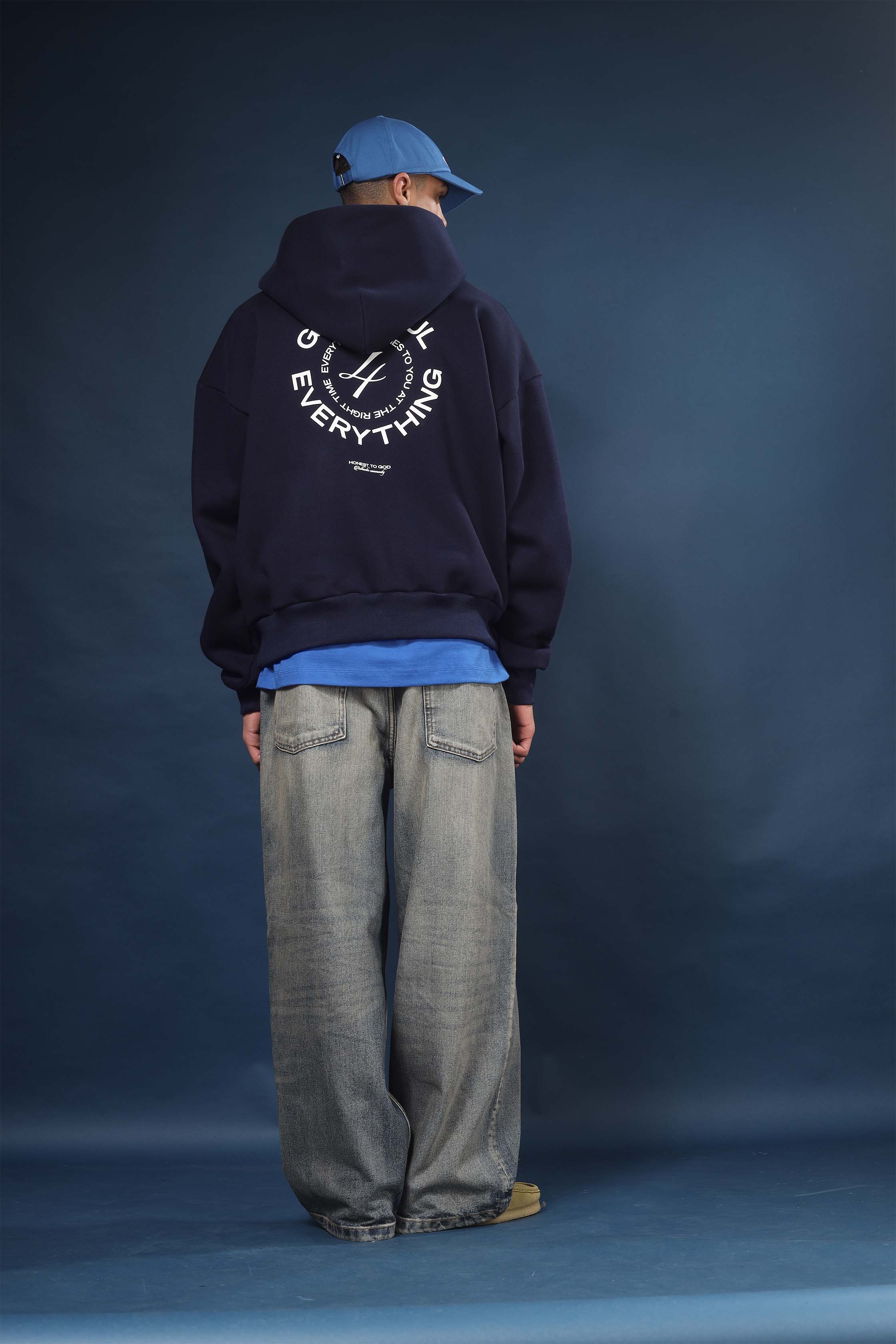 Model wearing Honest to God Navy Blue boxy hoodie for a 90s inspired international vibe.
