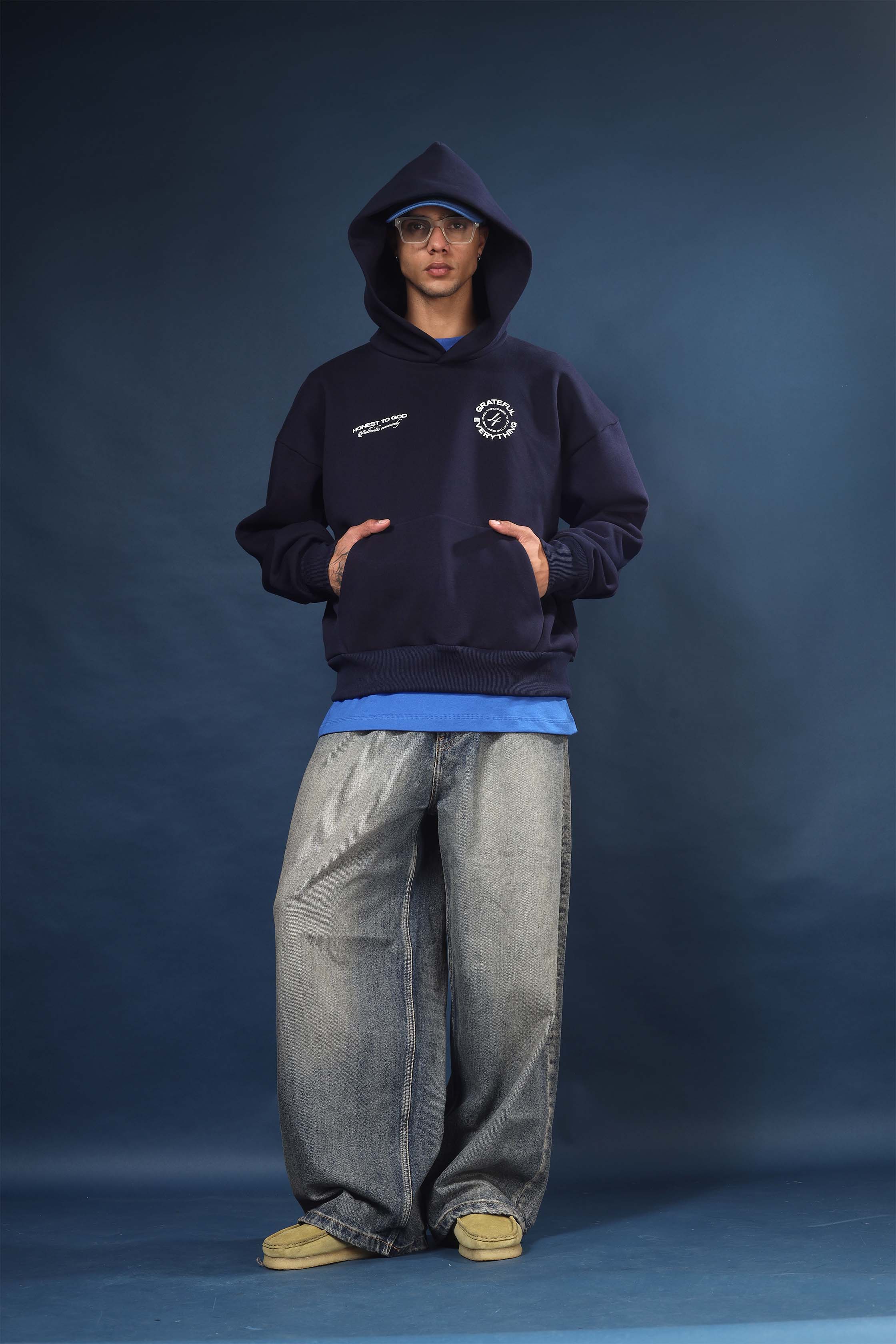 Model wearing Honest to God Navy Blue boxy hoodie for a 90s inspired international vibe.